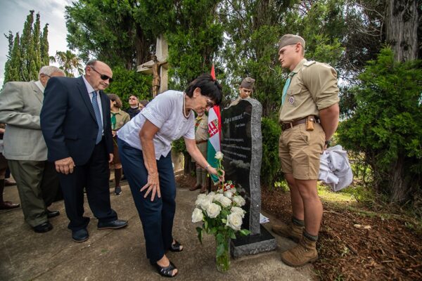 grief-care-placing-flowers-at-memorial-headstone-during-ceremony